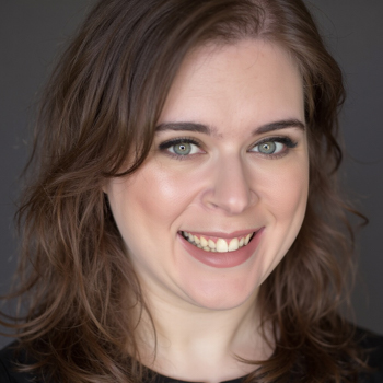 Headshot of a woman smiling at the camera in a black shirt.
