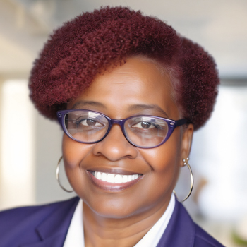 Headshot of a woman with dyed red hair and glasses smiling at the camera.
