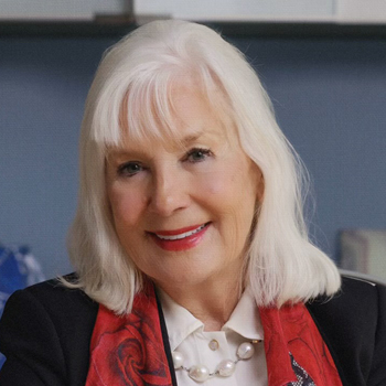 Headshot of a woman with shoulder-length white hair.