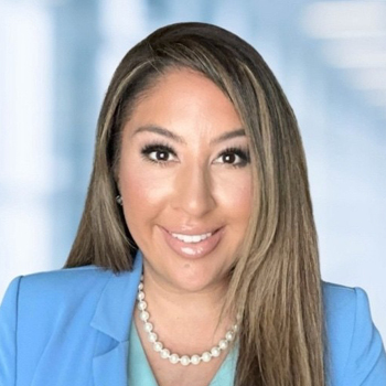 Headshot of a woman with long hair in a light blue blazer.