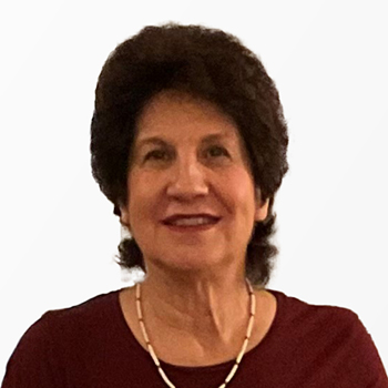 Headshot of a woman in front of a light silver background.